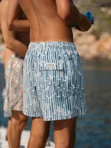 Short de baño Von Braun con estampado geométrico de rectángulos en tonos azules y blancos. Cuenta con cintura elástica, dos bolsillos laterales, un bolsillo trasero con solapa y logo de la marca.