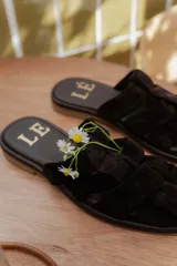 Sandalias bajas color beige con tiras de cuero entretejidas.