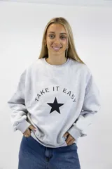 Buzo gris melange de cuello redondo y mangas largas, con estampa frontal que incluye la frase "TAKE IT EASY" y una estrella negra.