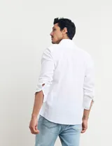 Camisa celeste de manga larga con cuello button-down, confeccionada en tejido rústico de algodón y lino.