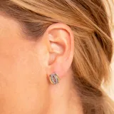 Caravanas de diseño circular elaboradas en una combinación de plata y oro, con incrustaciones de circonias brillantes.