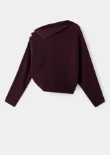Jersey de punto color marrón oscuro, con diseño recto, cuello asimétrico y manga larga. Presenta detalle de botones efecto joya en el hombro.