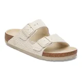 Sandalia Birkenstock modelo Arizona con diseño de doble correa con textura trenzada en color crudo. Cuenta con hebillas ajustables al tono, plantilla anatómica de corcho y suela de goma antideslizante.