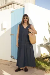 Vestido largo sin mangas de denim oscuro, con escote en V y bolsillos frontales aplicados.