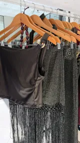 Top de un hombro dorado confeccionado en tela elastizada con textura acanalada, presenta frunce en el lateral y detalle de hebilla circular metálica en el bretel.