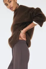 Pantalón de tiro alto en punto pesado, con corte bootcut y raya cosida en el frente. Presenta cierre frontal, pretina prolongada con corchete oculto y elástico en la cintura.