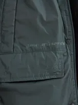 Campera de abrigo azul marino con capucha, cierre frontal con botones y cremallera, múltiples bolsillos y forro interior naranja.