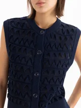 Chaleco color beige confeccionado en tejido semiliviano de galga 12, con calce regular, largo hasta la cadera y escote redondo clásico. Su diseño presenta una trama texturada con figuras geométricas.