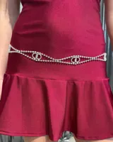 Cinturón de cadena plateada con incrustaciones de strass, diseñado con un patrón de eslabones entrelazados y doble línea decorativa.