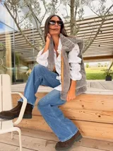 Chaleco de piel sintética en color gris, con diseño reversible. El interior presenta un forro de tela color mostaza con estampado floral bordado. Posee un corte holgado y sin mangas.