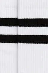 Pack de cinco pares de medias de caña media en color blanco con dos franjas horizontales negras en el borde superior. Presentan tejido acanalado en la caña y puntera reforzada.