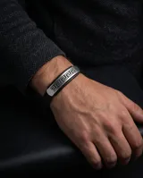 Pulsera de diseño masculino con banda central de acero inoxidable grabada con motivo de guarda griega y laterales de cuerina negra.