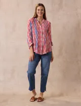 Blusa de gasa estampada multicolor, marca Ruby Rd. Tiene cuello a la base, escote en V, abertura central con botones y plisados en la parte delantera. Las mangas son 3/4 y tienen un largo regulable con presilla y botón.
