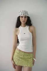 Minifalda de tiro bajo confeccionada en tejido texturizado color verde lima, con apliques de lentejuelas circulares brillantes.