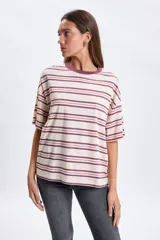 Remera de corte boxy y ajuste holgado, con diseño de rayas horizontales en tonos crudo y bordó. Presenta cuello redondo al tono y mangas cortas.