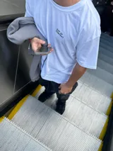 Remera blanca de algodón con corte oversize y estampado en la espalda con diseño geométrico en negro y la palabra 'OSTER' en la parte inferior.