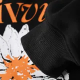 Canguro negro con capucha y bolsillo delantero, con estampado de margarita y texto en color naranja.