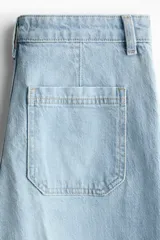 Jean de denim celeste de tiro alto con piernas amplias, bolsillos delanteros de parche y raya marcada al frente y en la espalda.