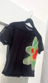 Top negro de microtul con estampado de orquídeas verdes.