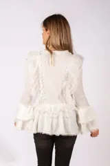 Sweater de punto acanalado color blanco, con diseño de volados en el frente y en las mangas acampanadas. Presenta detalles de encaje y terminaciones desflecadas.