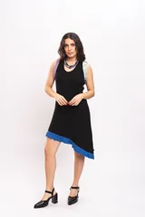 Vestido corto de punto negro con diseño asimétrico, sin mangas, con detalles de volados en tonos lila, celeste y azul en los tirantes y el borde inferior.