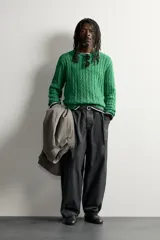 Sweater de punto verde con diseño de trenzas, cuello redondo y manga larga, de corte regular fit y acabados en rib.