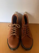 Borcego de cuero color marrón con cordones y suela de goma.