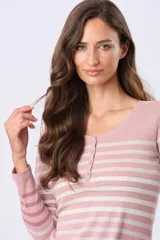 Remera de manga larga con diseño de rayas horizontales en tonos rosado y blanco. Presenta un escote redondo con una pequeña tapeta frontal con botones y aberturas laterales en el ruedo.