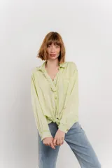 Camisa color crema de algodón con cuello camisero, botones y detalles de encaje en el escote.