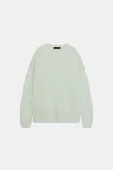 Jersey de punto color verde menta muy claro, de corte oversize, con cuello redondo y manga larga. Presenta acabados en rib en puños, cuello y bajo.