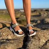 Sandalias de plataforma con tiras de cuero sintético en blanco, negro y plateado.