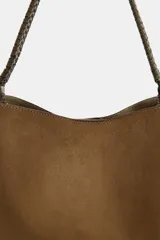 Bolso de hombro formato saca en color marrón, con asa superior trenzada y cierre mediante clip metálico. Incluye compartimento interior extraíble con cremallera.