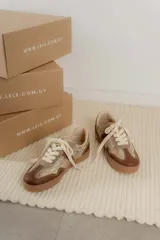 Championes urbanos de diseño acolchado, combinando tonos marrones, beige y detalles metalizados con textura. Cuentan con cordones al tono y suela de goma color caramelo.