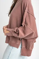 Sweater de algodón peinado con efecto lavado, de corte oversize, cuello redondo y mangas largas con costuras visibles.