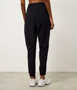 Pantalón jogger deportivo de microfibra, color tostado, con cintura elástica ajustable y puños elásticos en los tobillos. Diseño funcional y liviano, ideal para actividades físicas.