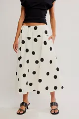 Falda midi de corte A en popelina de algodón color blanco, con estampado de lunares negros y cintura baja elastizada.