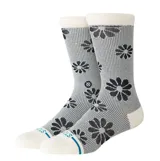 Medias de caña media Stance con diseño de flores negras sobre fondo gris texturizado. Presentan puntera, talón y puño en color crema, con detalle de logo bordado en el lateral.