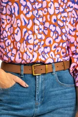 Camisa de viscosa color naranja con estampado animal print en tonos rosa y azul. Corte oversize, cuello clásico y cierre frontal con botones.