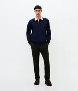 Buzo masculino de algodón con felpa, color beige, con cuello polo blanco contrastante, manga larga y puños acanalados.