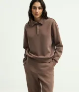 Pantalón boot cut de algodón con felpa y cintura elástica, en color beige.