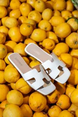 Sandalias planas blancas de diseño destalonado, con pala ancha troquelada y suela baja.