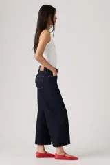 Jean de denim azul oscuro con corte wide leg y diseño cropped al tobillo, con tiro medio y costuras en contraste.