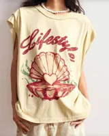 Remerón color crema con cuello redondo y mangas cortas. Estampado frontal con la palabra 'Lifestyle' en rojo y dibujo de una concha de mar.