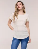 Blusa de silueta relajada color beige, confeccionada en tejido de punto calado estilo pointelle, con escote redondo amplio, mangas cortas de corte caído con dobladillo y detalle de presilla decorativa con botón a tono, y ruedo curvo.