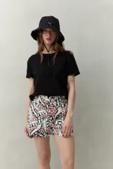 Gorro tipo bucket color crudo con borde desflecado y cordón ajustable.