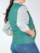 Chaleco acolchado verde con cierre frontal y bolsillos laterales.