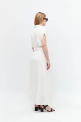 Vestido midi blanco con cuello camisero, escote en V, mangas cortas y falda plisada. Incluye cinturón con hebilla forrada.