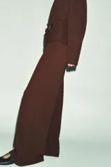 Pantalón de tiro alto con cintura elástica y diseño de pernera ancha, confeccionado en tejido de punto con textura.