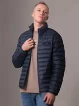 Campera inflada Calvin Klein color azul marino, con cuello alto, cierre frontal con cremallera, bolsillos laterales y logo de la marca en el pecho.