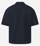 Camisa de manga corta color negro, con diseño boxy, cuello clásico y abotonado frontal.